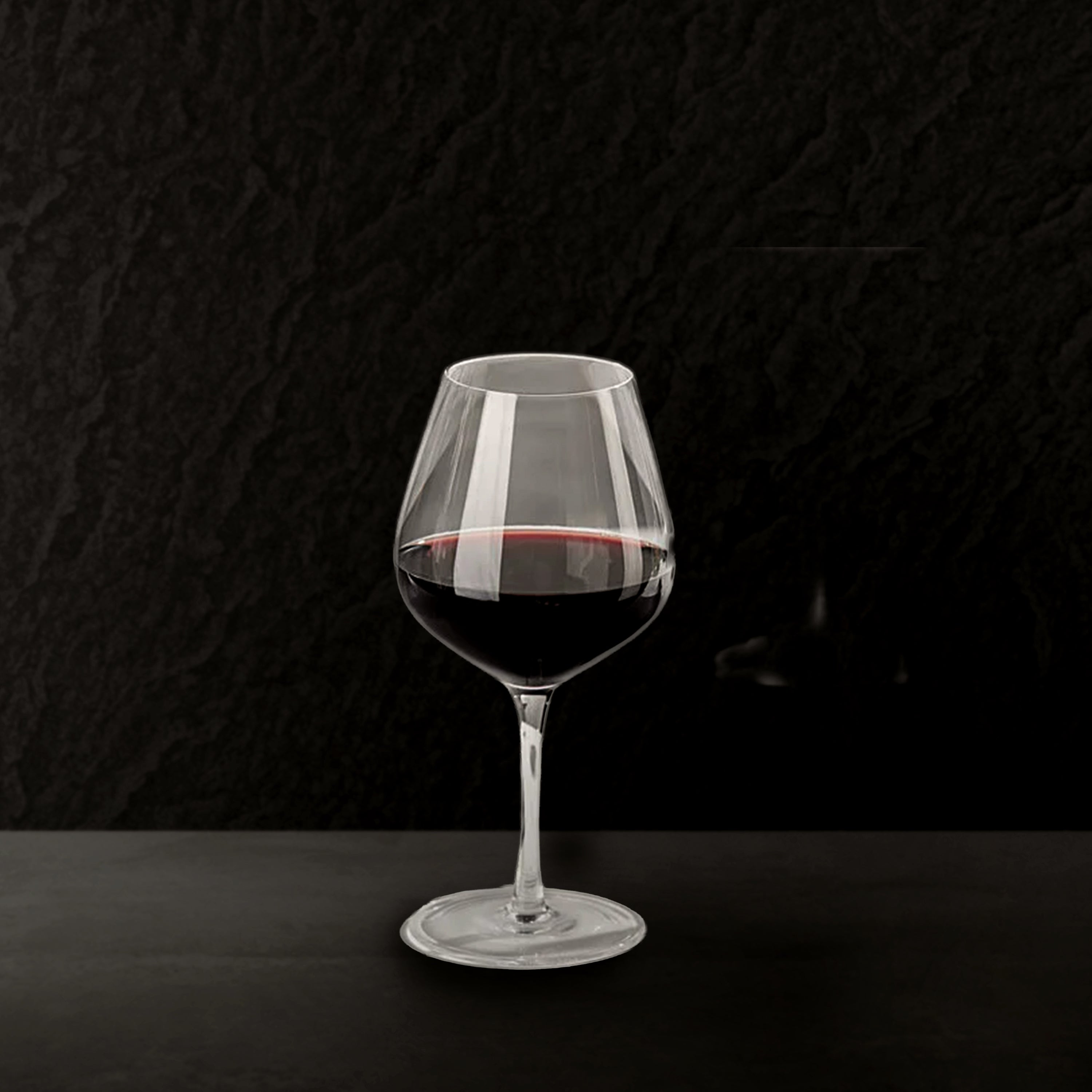 Wine glass with red wine on a black background