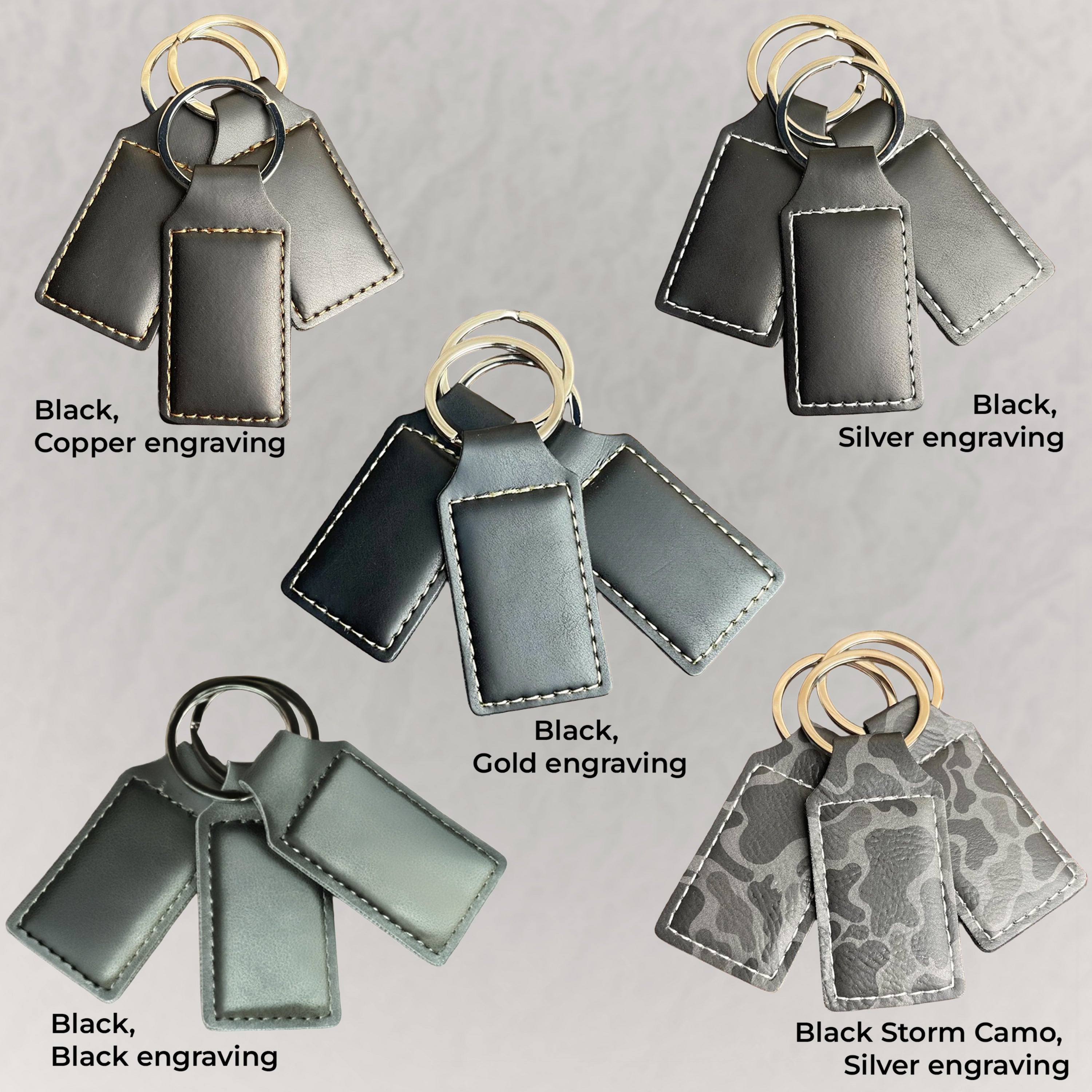 Set of black keychains with different engraving options on a gray background