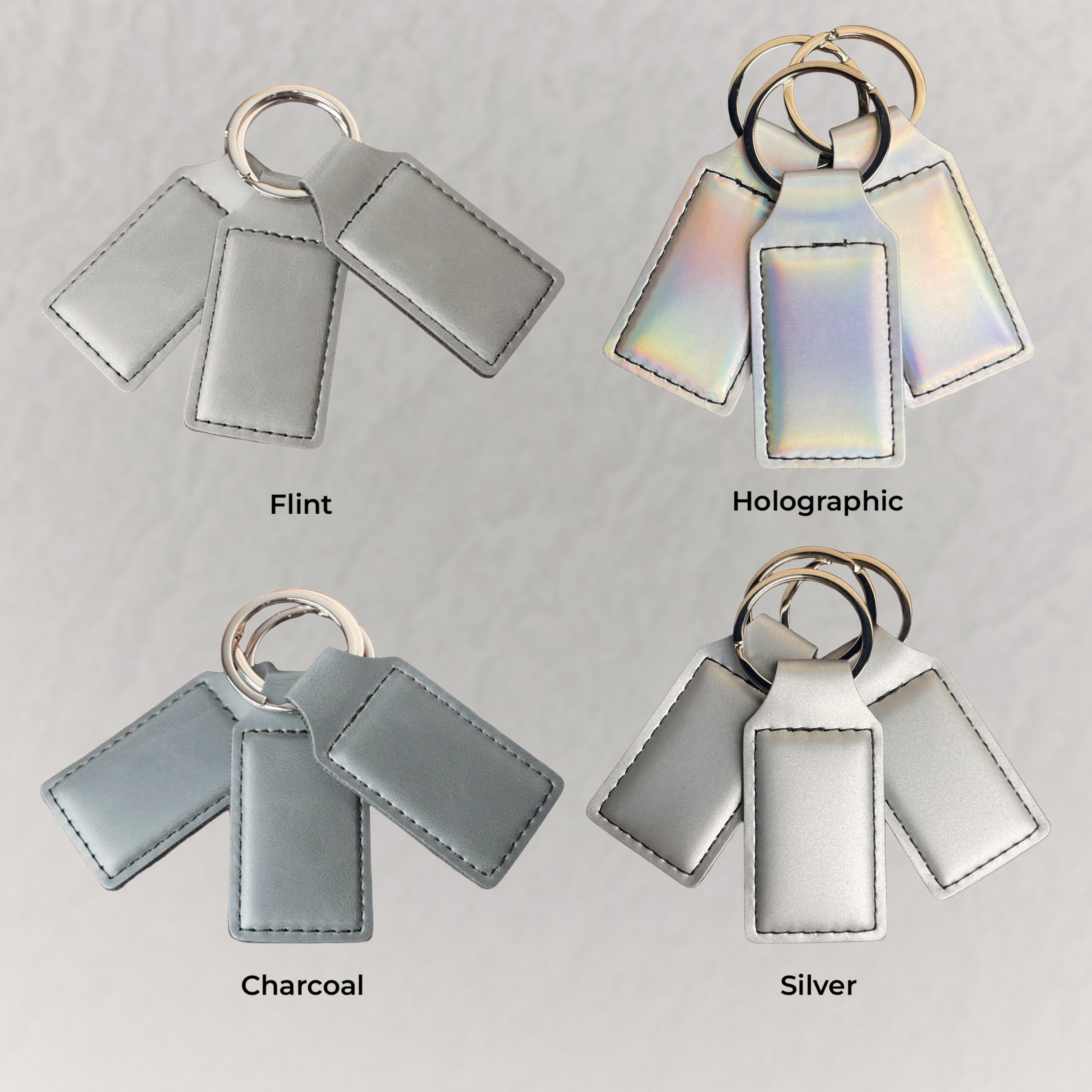 Keychains in Flint, Holographic, Charcoal, and Silver on a gray background