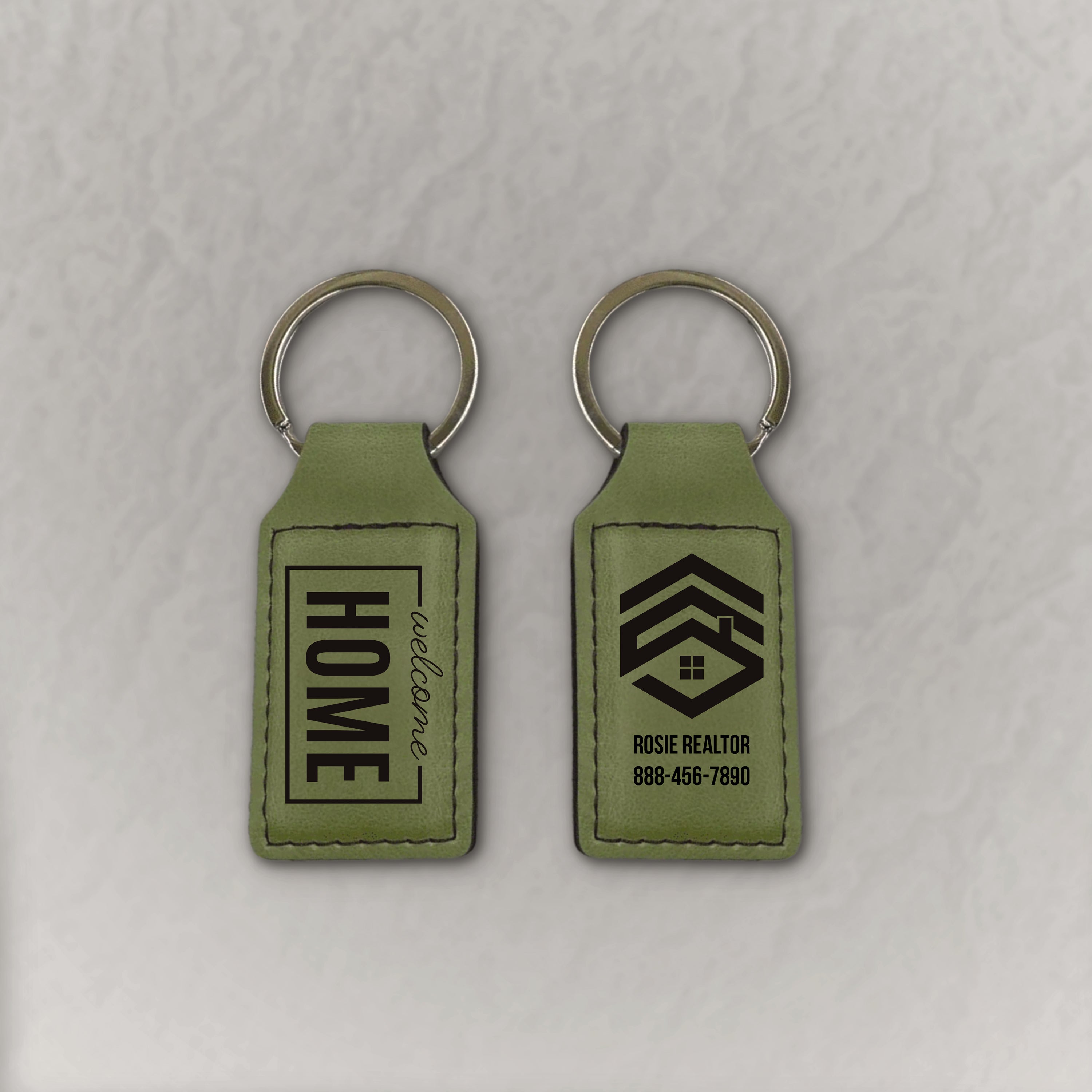 Green keychains with Welcome Home and Logo on gray background