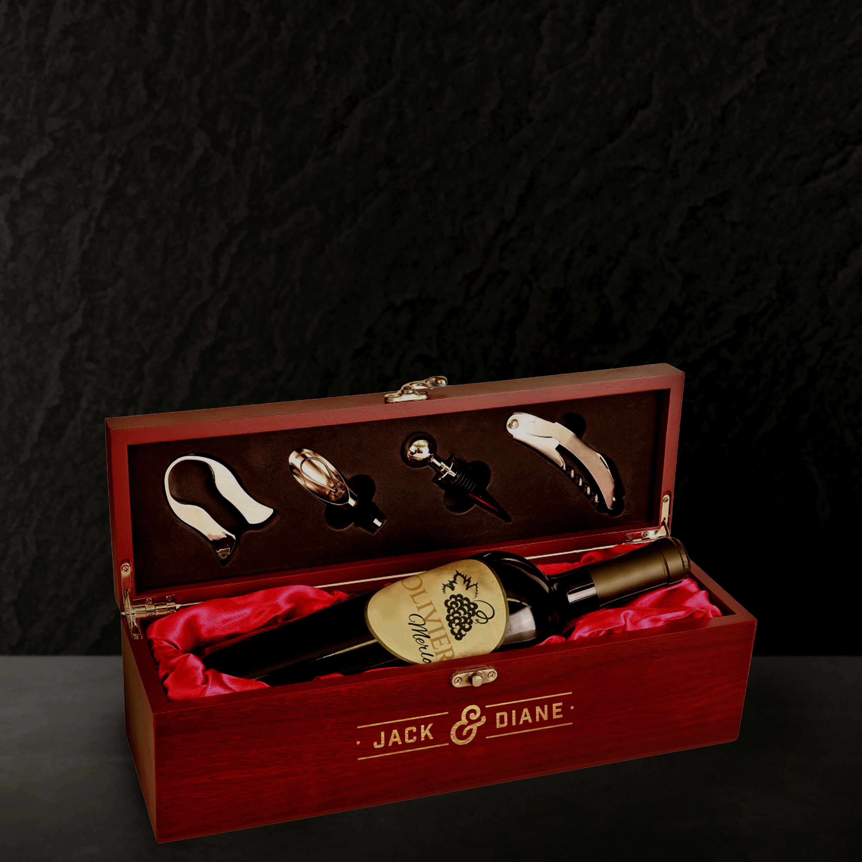 Wine bottle set with accessories in a red wooden box on a dark background
