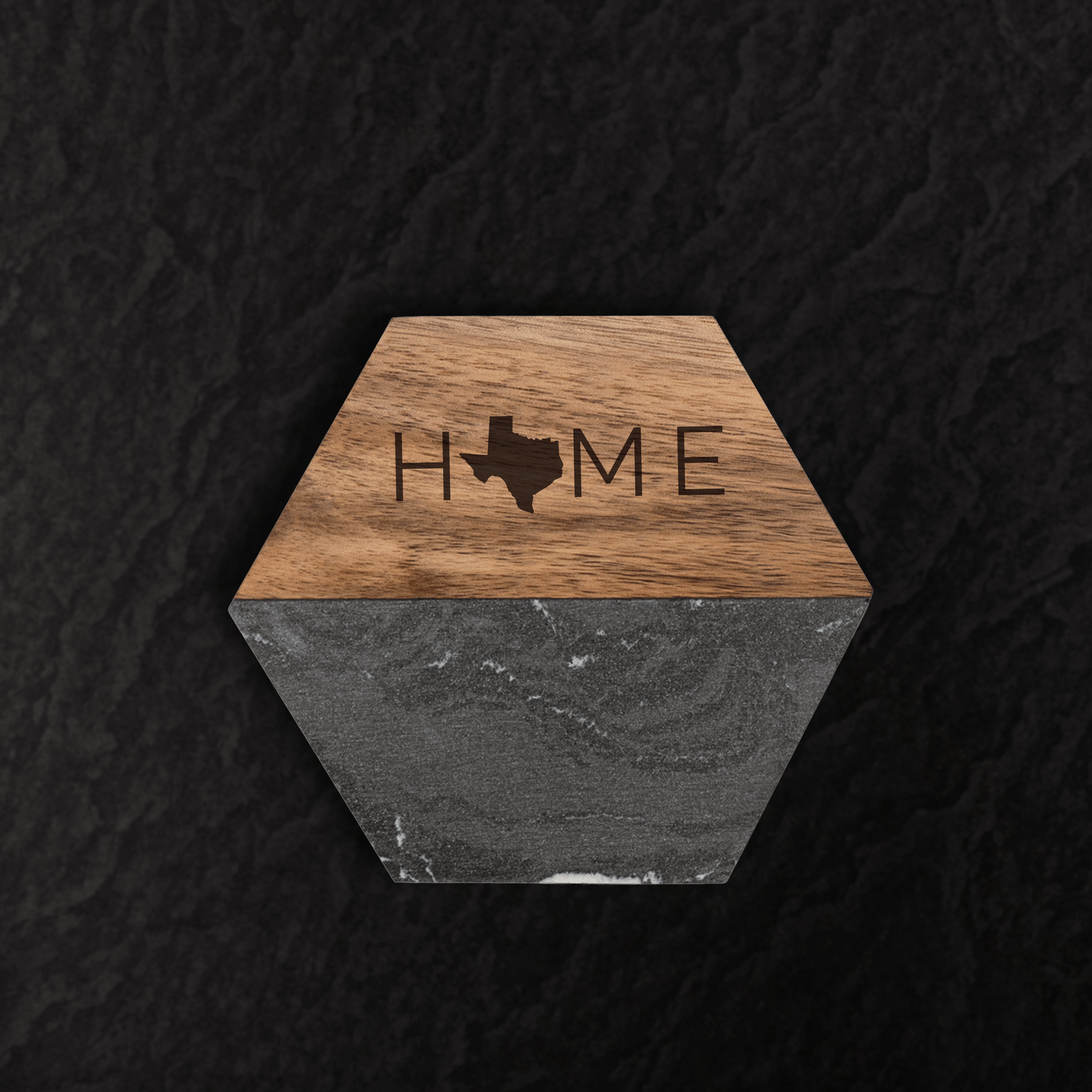 Hexagonal coaster with wooden top and gray bottom, featuring 'HOME' and a Texas outline design.