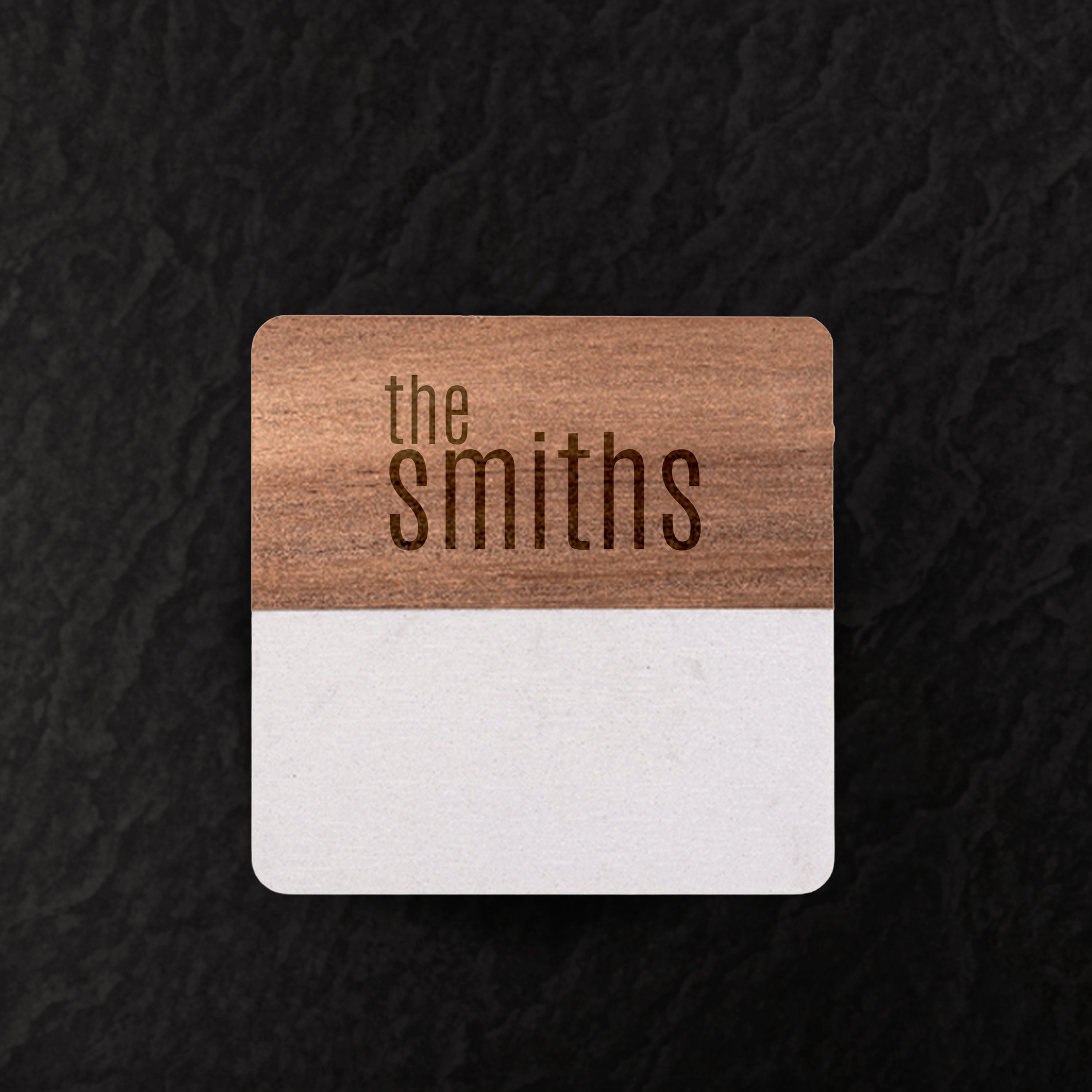 Wooden coaster with 'the smiths' engraving on a dark textured background