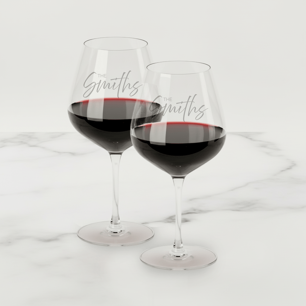 Two glasses of red wine on a white marble surface