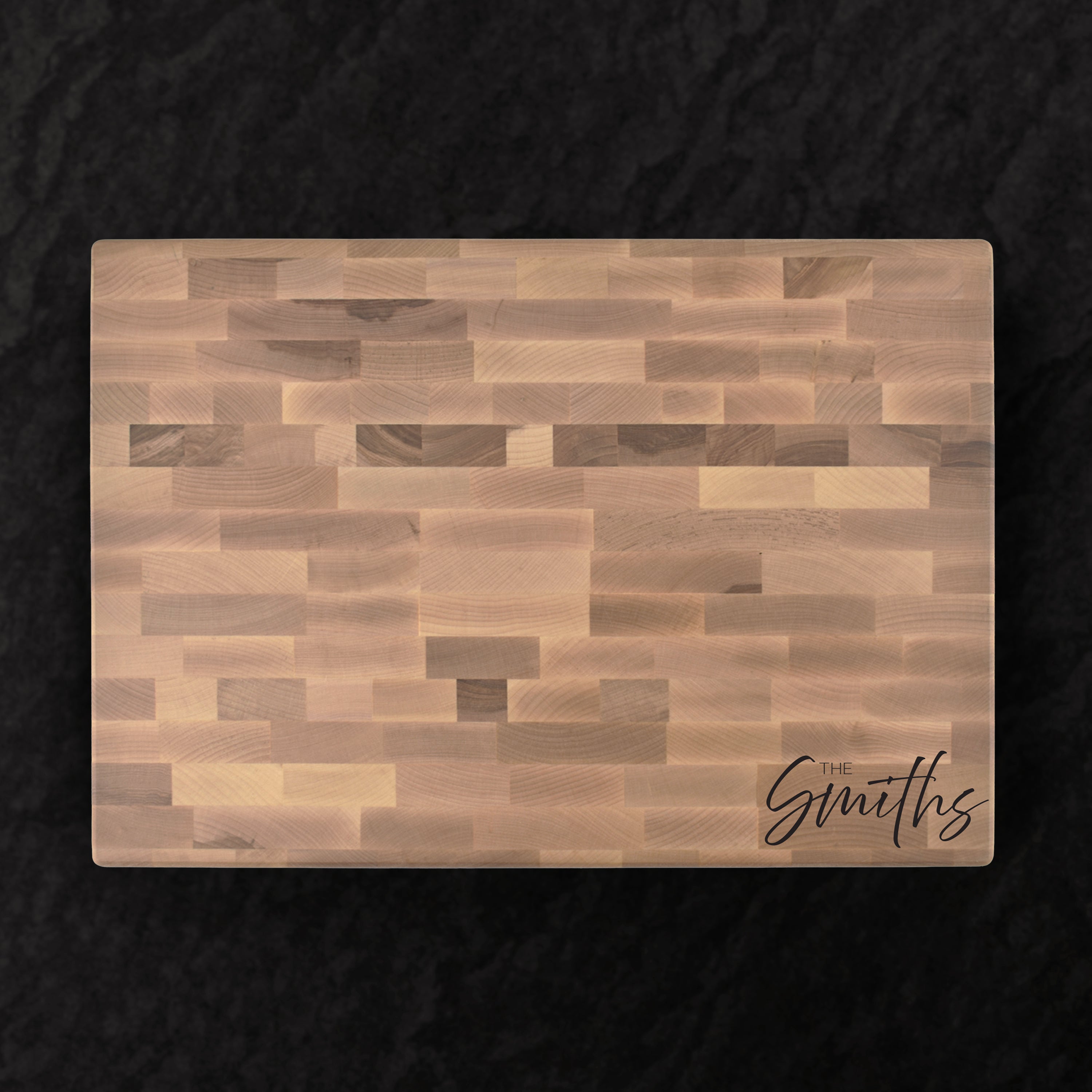 Wooden cutting board with 'The Smiths' engraving on a dark background
