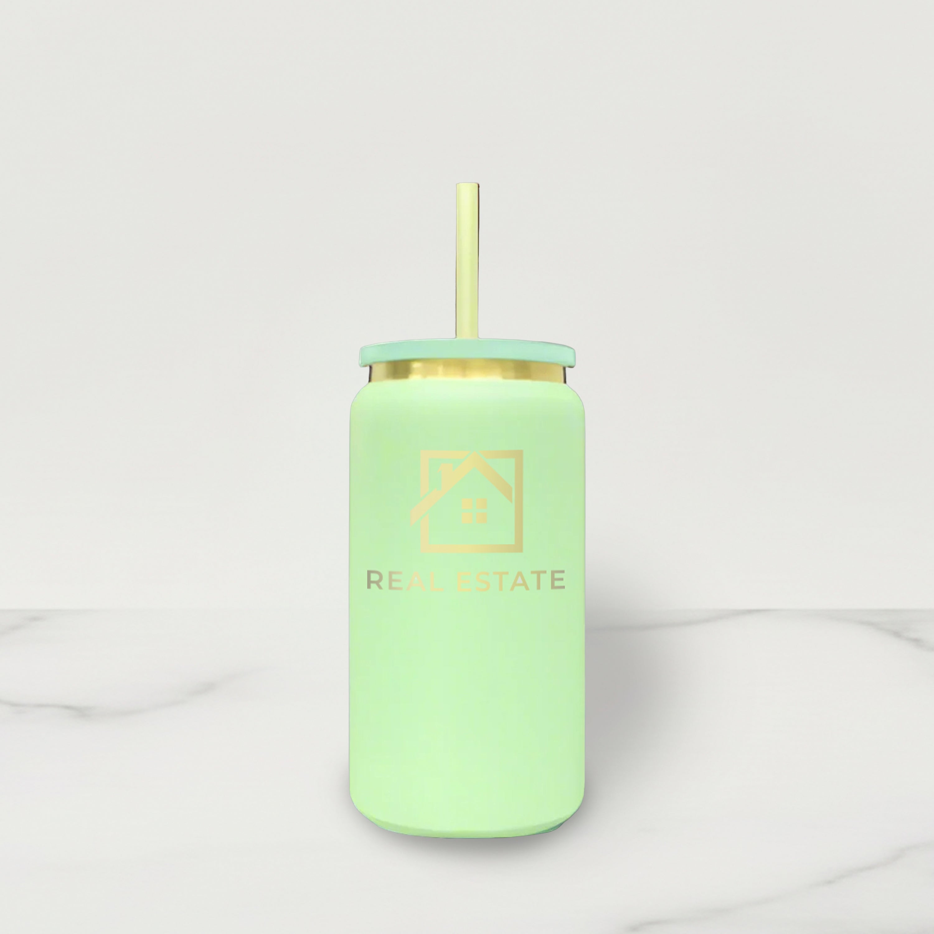 Light green tumbler with gold lid and straw on a white background