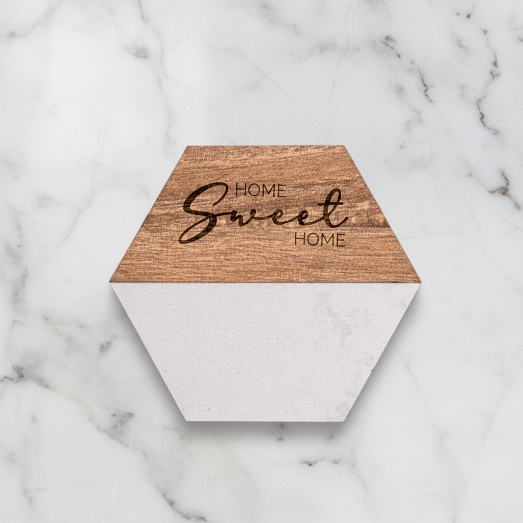 Hexagonal wooden coaster with 'Home Sweet Home' text on a marble surface