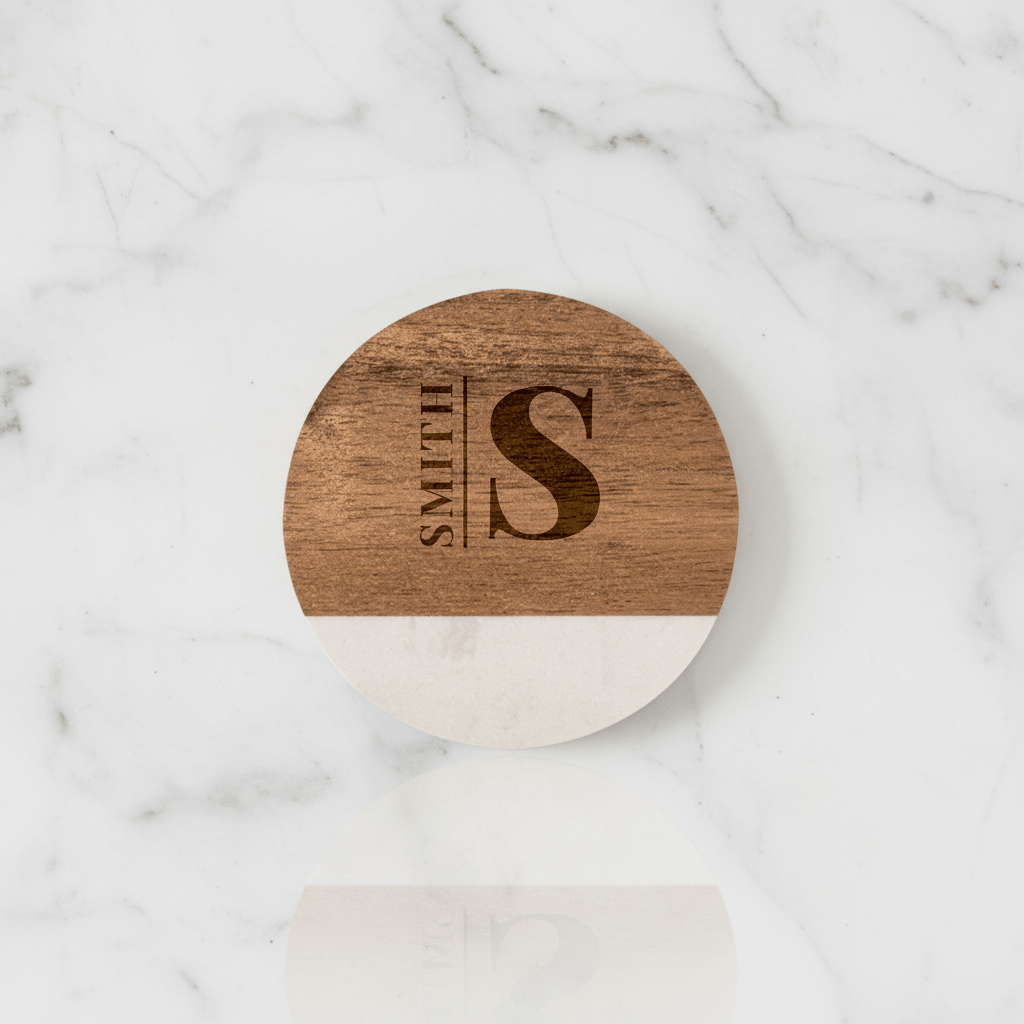 Wooden coaster with 'Smith & Son' engraving on a marble surface