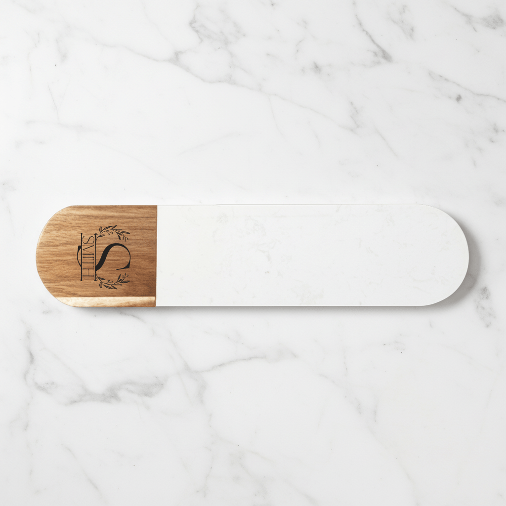 White and wooden charcuterie board with engraved design on a marble surface