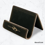 Black business card holder with gold engraving on a marble background