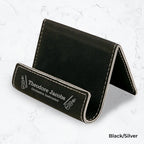 Black business card holder with silver engraving on a marble background