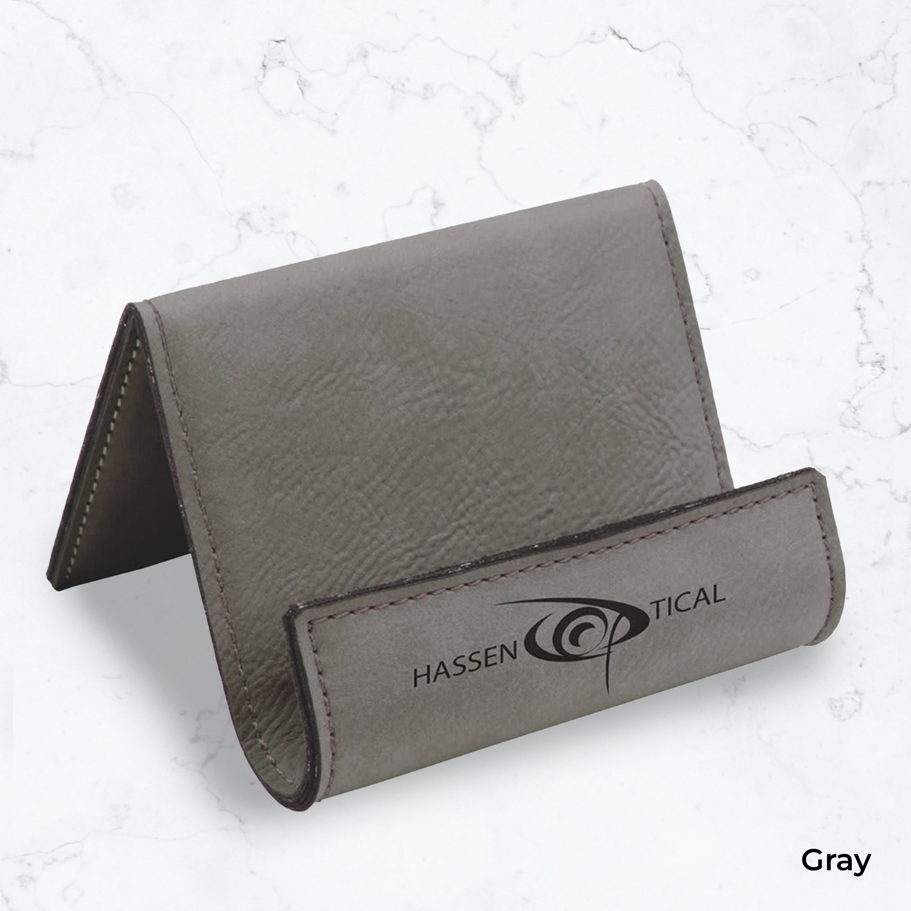 Gray business card holder with black engraving on a marble background
