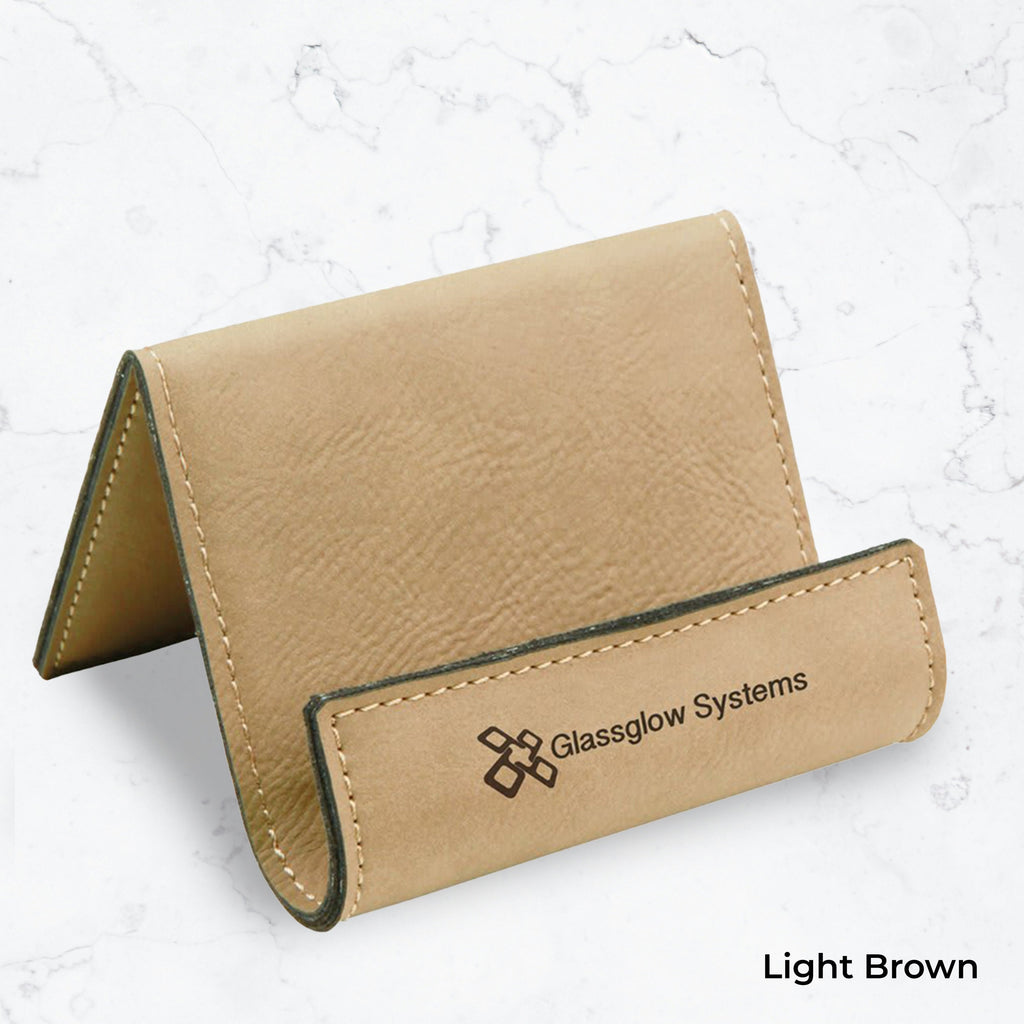 Light brown business card holder with black engraving on a marble background