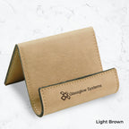 Light brown business card holder with black engraving on a marble background