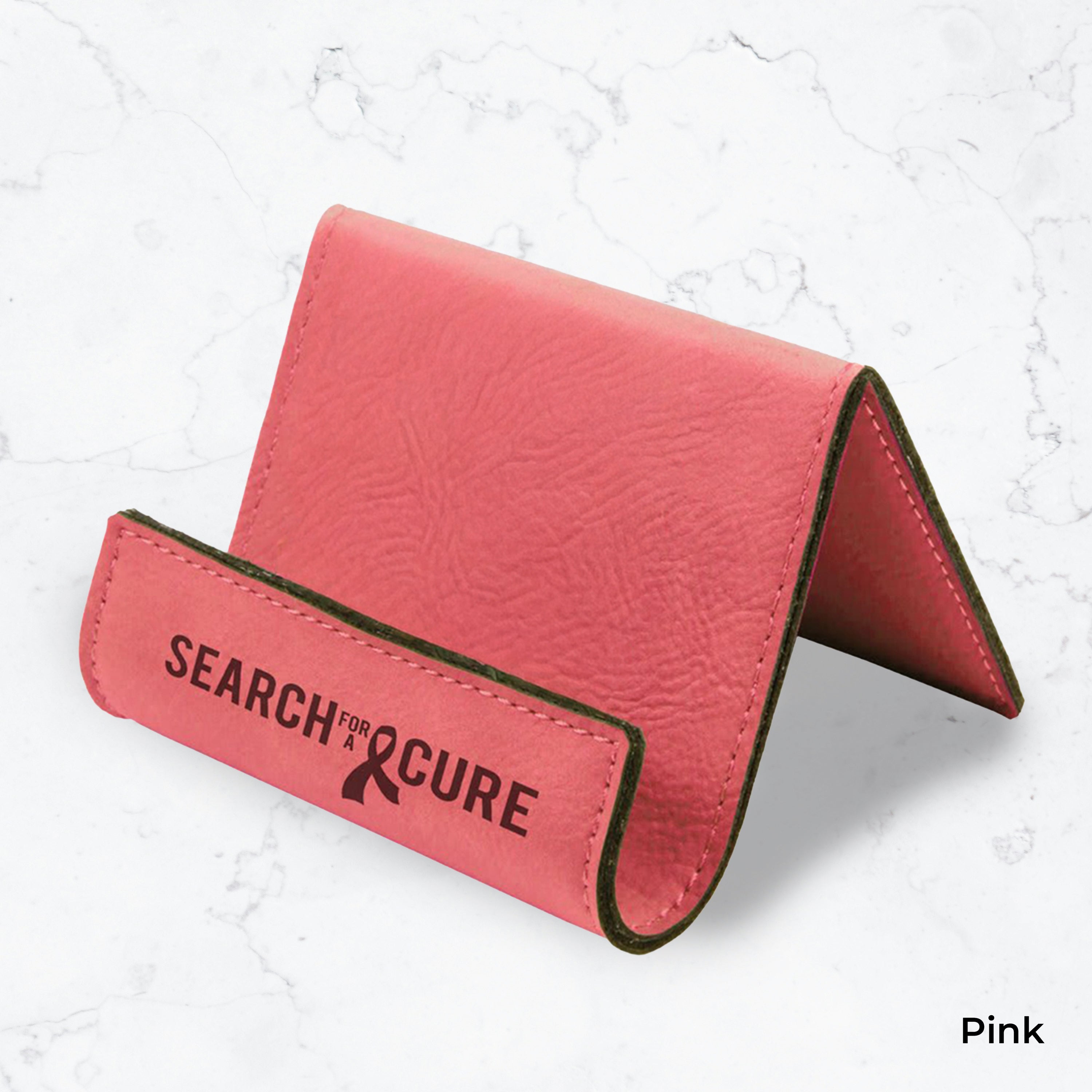 Pink business card holder with black engraving on a marble background