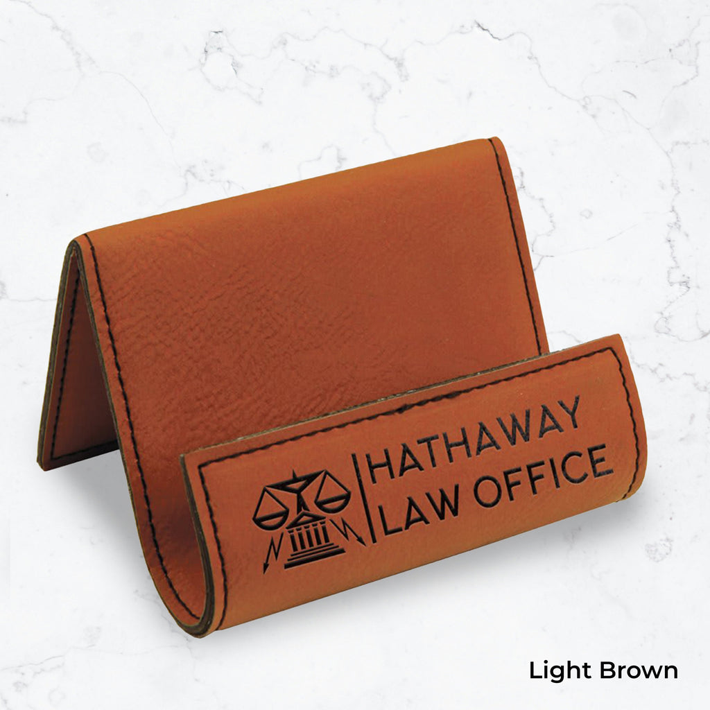 Brown business card holder with black engraving on a marble background