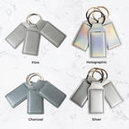 Keychains in Flint, Holographic, Charcoal, and Silver on a textured white background