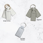 Three keychains in different colors on a marble background