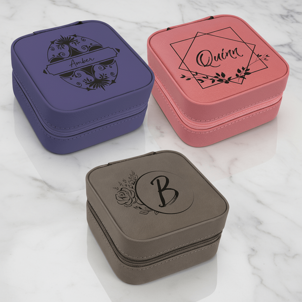 Three jewelry boxes in purple, pink, and gray with personalized designs on a marble surface.