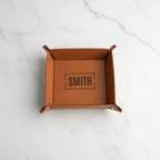 Brown leather tray with 'SMITH' engraving on a marble surface