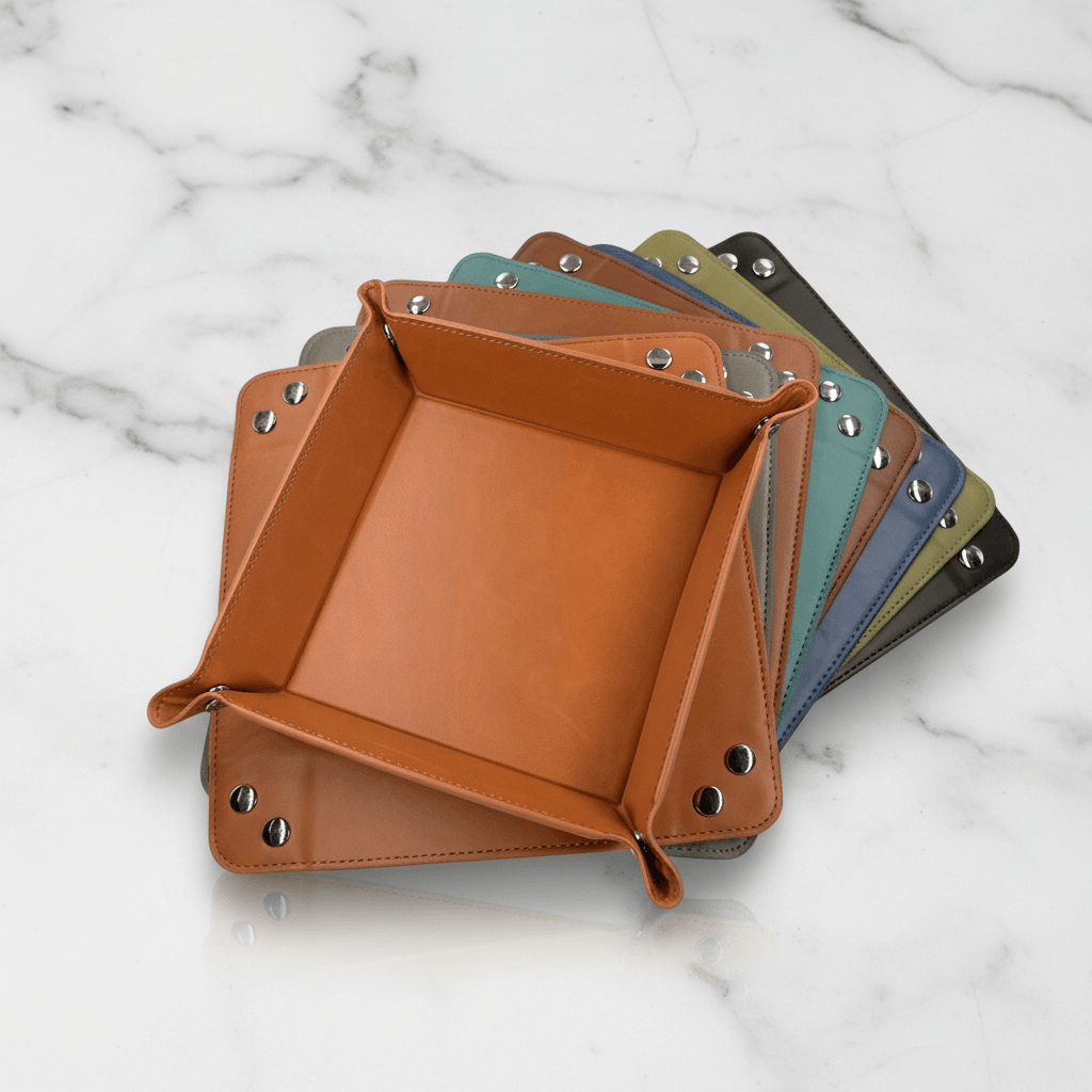 Set of square leather trays in various colors on a marble surface