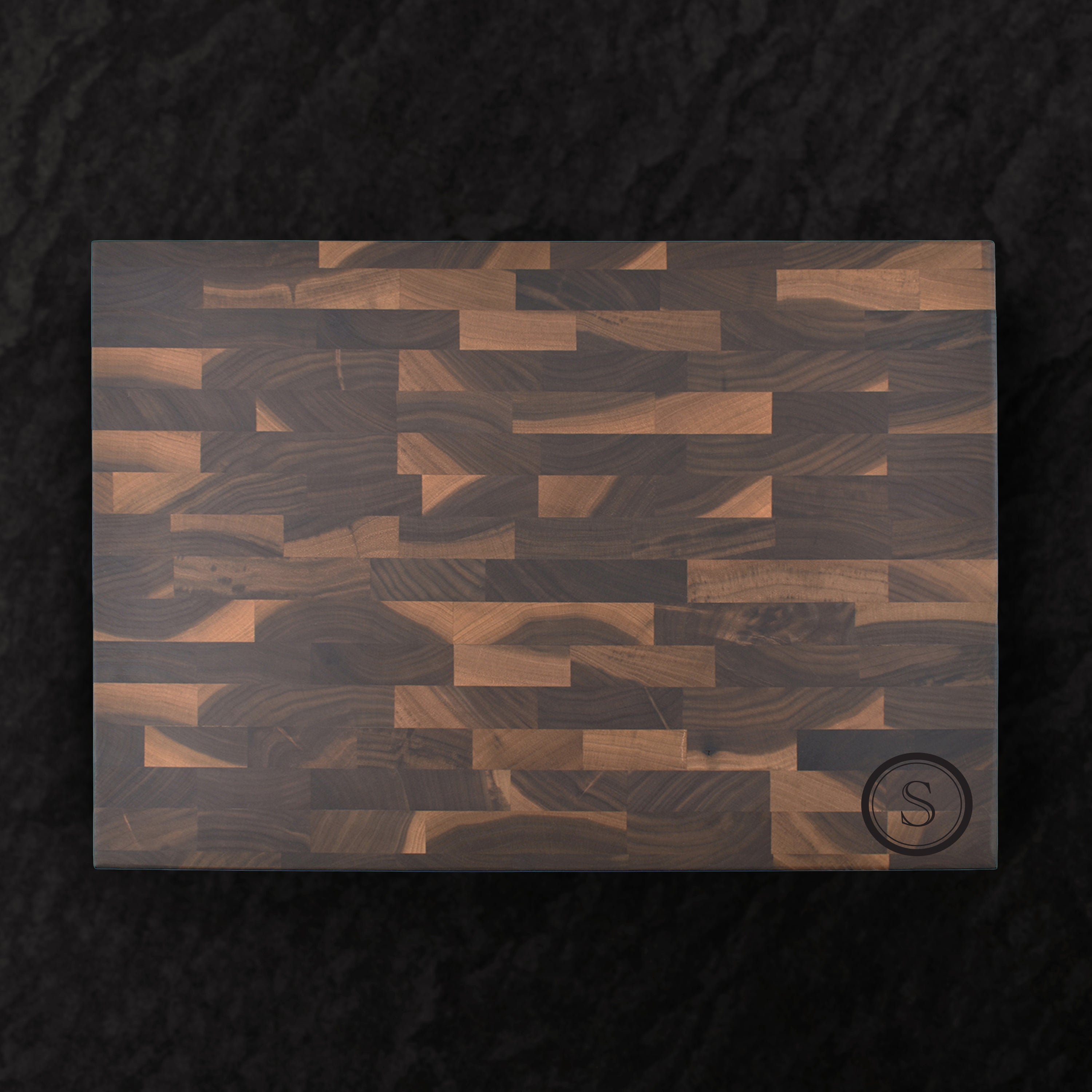 Wooden cutting board with geometric pattern on a dark background