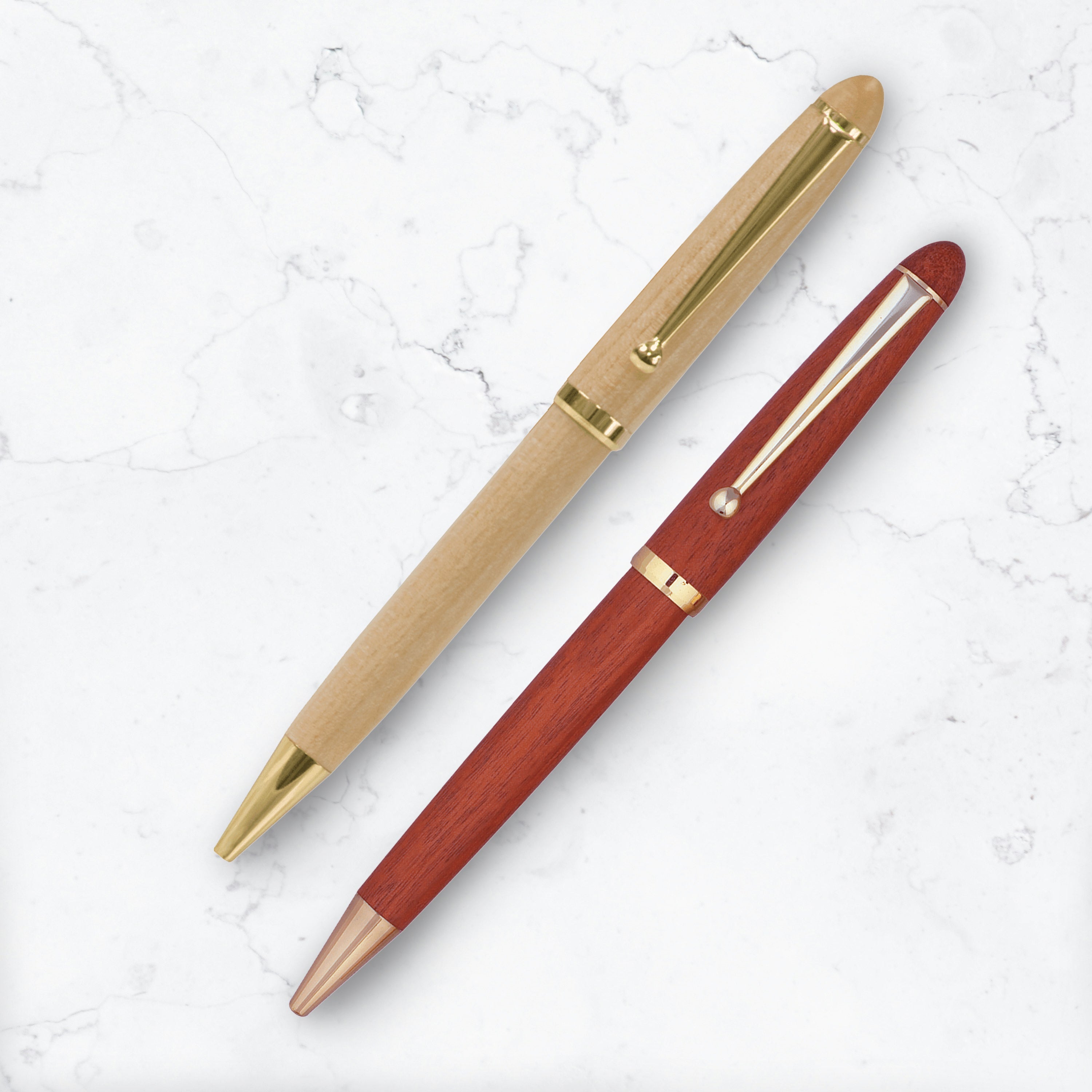 Two wood barreled ballpoint pens on marble background