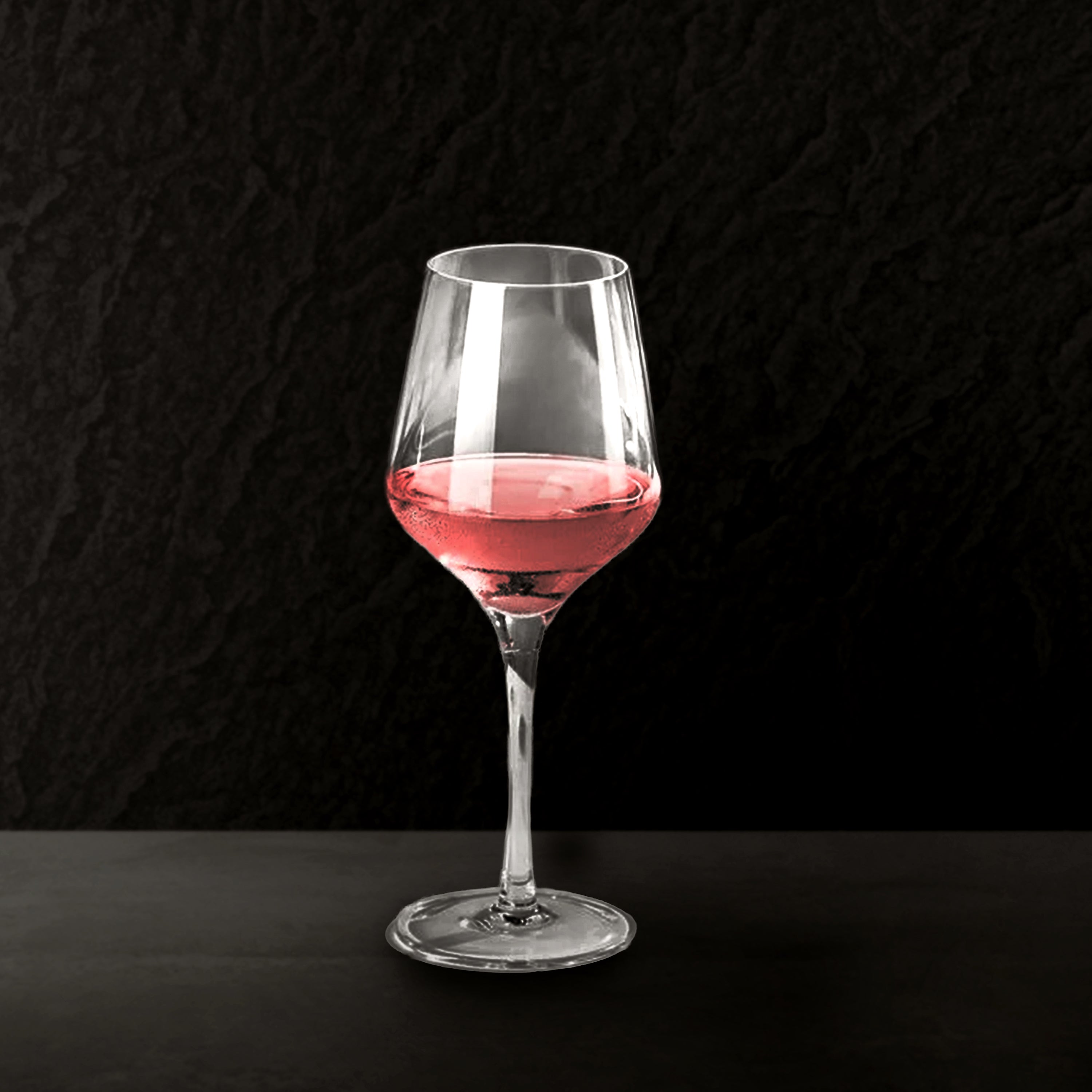 Wine glass with pink wine on a black background